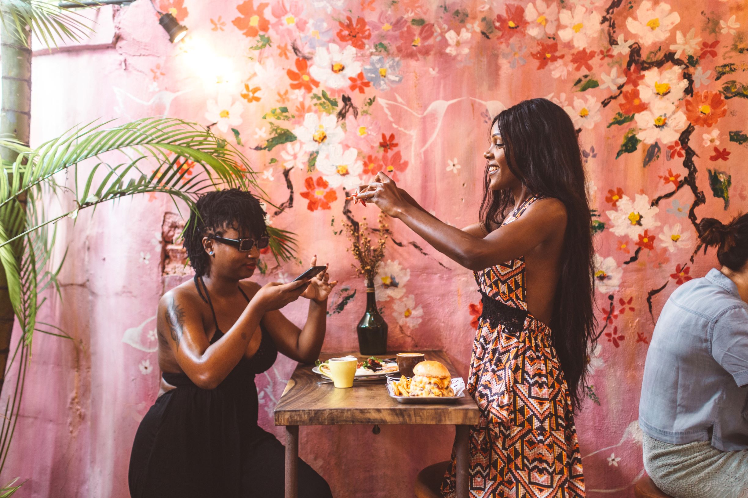 two women taking photos of their food with their cell phones