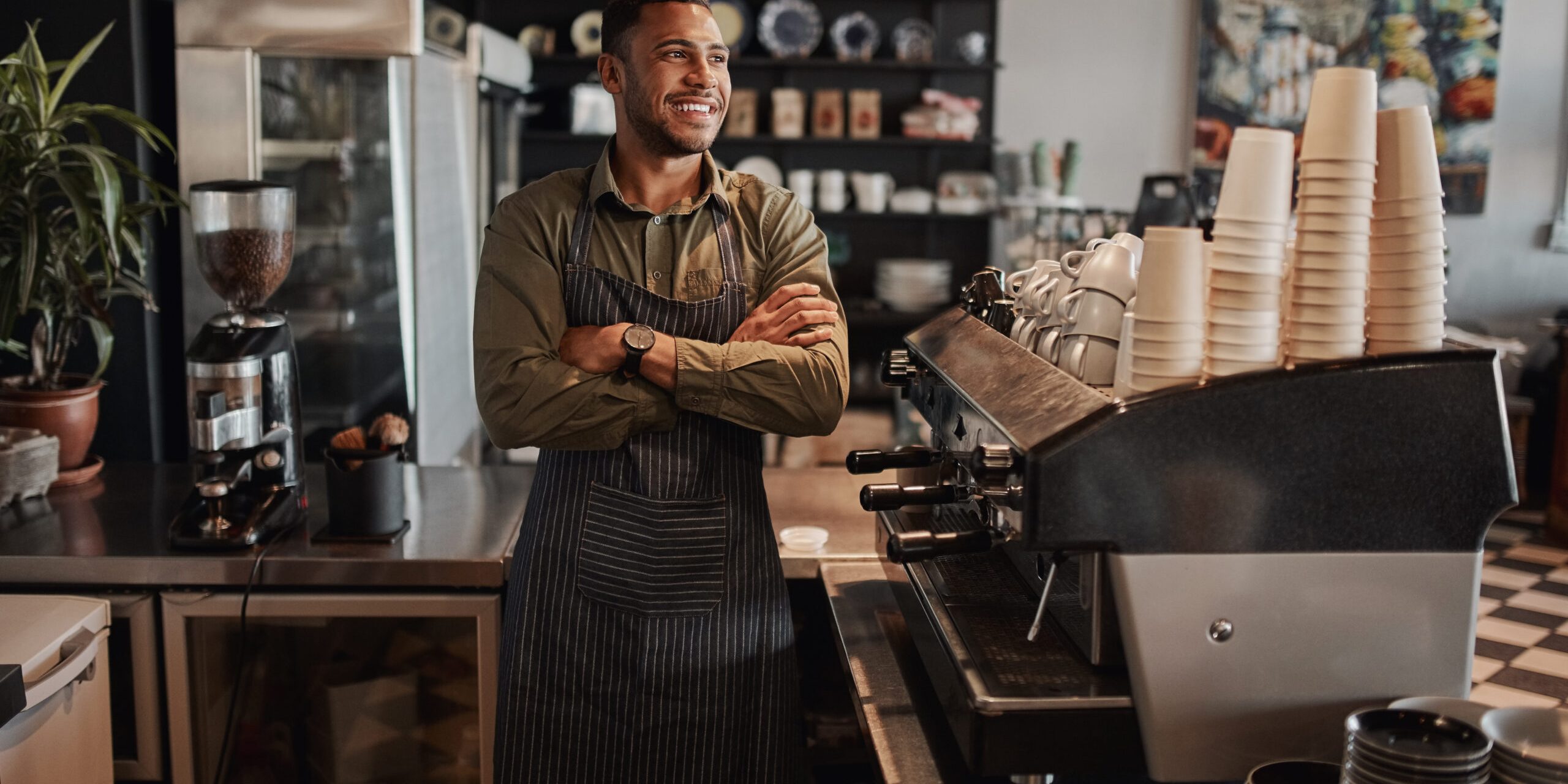coffee shop owner behind the counter smiling