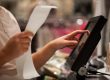 Young woman hands scaning / entering discount / sale on a receip