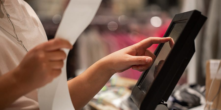 Young woman hands scaning / entering discount / sale on a receip