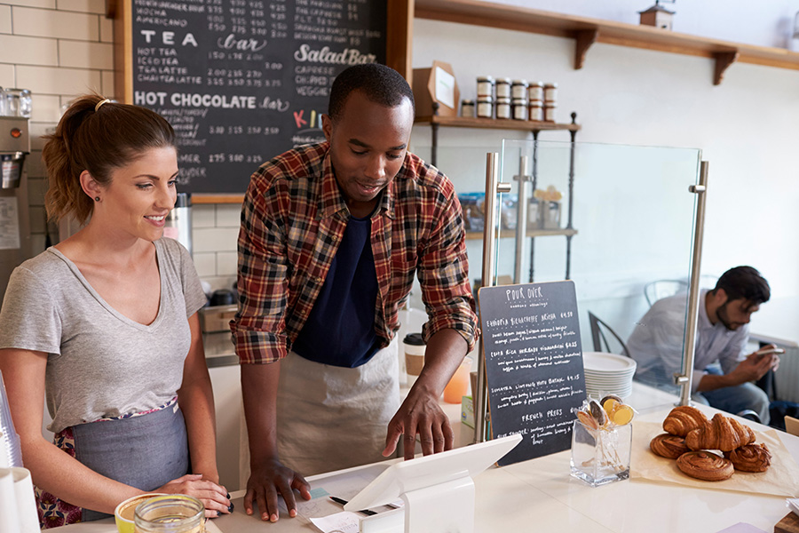 Barista at coffee shop performing POS training