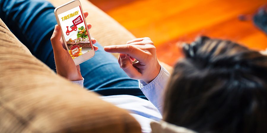 Woman ordering take away food by internet with a mobile phone wh