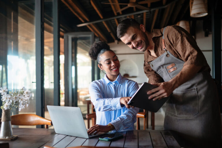 Managers discussing restaurant margin on a laptop and tablet